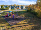 Thumbnail 33 of 34 - a playground in a park with apartments in the background