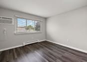 Thumbnail 26 of 34 - an empty living room with wood flooring and a window