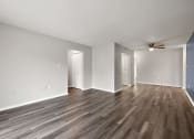 Thumbnail 29 of 34 - an empty living room with wood flooring and a ceiling fan