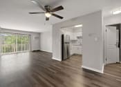 Thumbnail 6 of 34 - an empty living room with a refrigerator and a ceiling fan
