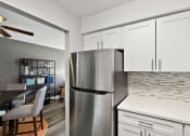 Thumbnail 3 of 34 - a kitchen with a stainless steel refrigerator and white cabinets
