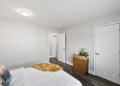 Thumbnail 21 of 34 - a bedroom with white walls and a bed with a yellow blanket