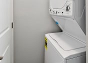 Thumbnail 18 of 34 - a washer and dryer in a white room with a door