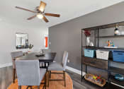 Thumbnail 7 of 34 - a dining room with a table and chairs and a ceiling fan
