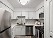 Thumbnail 1 of 34 - a white kitchen with stainless steel appliances and white cabinets