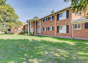Thumbnail 12 of 12 - A red brick building with a green lawn in front.