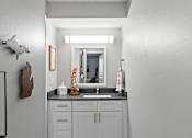 Thumbnail 13 of 25 - A bathroom with a sink and a mirror.
