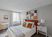 Thumbnail 17 of 25 - A bedroom with a bed, desk, chair, and two paintings on the wall.