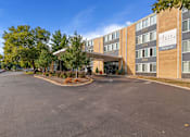 Thumbnail 25 of 25 - A parking lot in front of a brick building with a sign that reads "Southpointe".