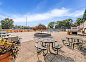 Thumbnail 21 of 25 - A sunny day at the park with picnic tables and benches.