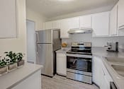 Thumbnail 16 of 116 - A kitchen with a stainless steel refrigerator, oven, and sink at The Waverly on the Lake - Belleville, MI Apartment , Belleville, Michigan