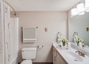 Thumbnail 25 of 116 - A white toilet sits next to a sink in a bathroom at The Waverly on the Lake - Belleville, MI Apartment , Michigan