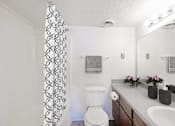 Thumbnail 48 of 116 - A white toilet sits in a bathroom next to a sink at The Waverly on the Lake - Belleville, MI Apartment , Belleville, MI