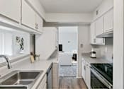 Thumbnail 95 of 116 - A modern kitchen with white cabinets and stainless steel appliances at The Waverly on the Lake - Belleville, MI Apartment , Michigan, 95050