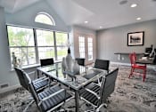 Thumbnail 24 of 26 - A modern dining room with a glass table and chairs.