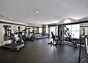 Thumbnail 23 of 26 - A spacious gym with a variety of equipment.