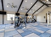 Thumbnail 24 of 39 - A spacious gym with a variety of equipment and a checkered floor.