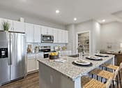 Thumbnail 2 of 39 - A modern kitchen with a granite countertop and stainless steel appliances.