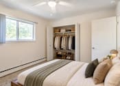 Thumbnail 10 of 17 - A bedroom with a bed, pillows, a closet, and a window.