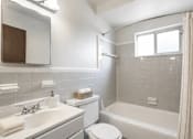 Thumbnail 11 of 17 - A white toilet sits next to a sink in a bathroom.