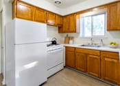 Thumbnail 1 of 17 - A kitchen with wooden cabinets and white appliances.