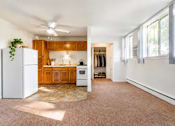 Thumbnail 3 of 17 - A kitchen with wooden cabinets and a white refrigerator.