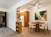 Thumbnail 5 of 17 - A room with a brown table and chairs, a wooden cabinet, and a painting on the wall.