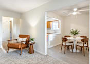 Thumbnail 8 of 17 - A living room with a brown chair and a white table.