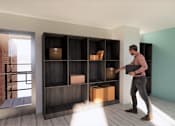 Thumbnail 44 of 44 - A man is carrying a box into a room with a large shelf. at The Park on 13 Apartments - Royal Oak, MI Apartments, Michigan, 48073