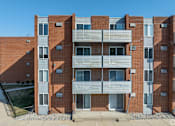 Thumbnail 39 of 44 - A red brick building with a white van parked in front. at The Park on 13 Apartments - Royal Oak, MI Apartments, Royal Oak
