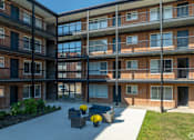 Thumbnail 38 of 44 - Apartment complex with a courtyard and a bench at The Park on 13 Apartments - Royal Oak, MI Apartments, Michigan