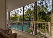 Thumbnail 70 of 87 - Covered balcony overlooking pool and wooded area at Village Club of Farmington Hills Apartments, Farmington Hills, 48331
