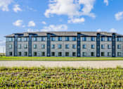 Thumbnail 2 of 23 - A large building with a flat roof and multiple windows.