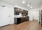 Thumbnail 1 of 18 - a kitchen with dark wood cabinets and white countertops and a refrigerator