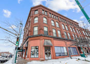 Thumbnail 3 of 18 - A red brick building with a green awning and a green traffic light.