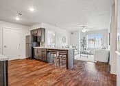Thumbnail 6 of 23 - A kitchen with wooden floors and a marble counter.