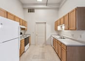 Thumbnail 4 of 21 - A kitchen with wooden cabinets and a white refrigerator.