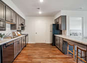 Thumbnail 5 of 23 - A kitchen with wooden floors and a white counter top.