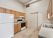 Thumbnail 6 of 21 - A kitchen with white appliances and wooden cabinets.