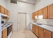 Thumbnail 7 of 21 - A kitchen with wooden cabinets and a white stove top oven.
