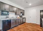 Thumbnail 23 of 23 - A kitchen with wooden cabinets and a white countertop.