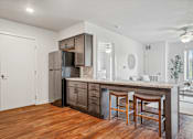 Thumbnail 22 of 23 - A kitchen with wooden floors and a white ceiling.