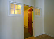 Thumbnail 25 of 27 - A white door with a window above it is open.