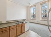 Thumbnail 8 of 18 - A kitchen with wooden cabinets and a window.