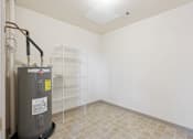 Thumbnail 16 of 18 - A room with a water heater and a tiled floor.