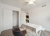 Thumbnail 9 of 18 - a living room with a white desk and chair and a closet