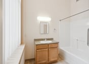 Thumbnail 15 of 18 - A bathroom with a sink, mirror, and a glass shower stall.