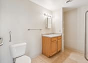 Thumbnail 15 of 21 - A white toilet sits next to a sink in a small bathroom.