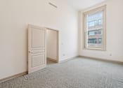 Thumbnail 13 of 18 - A room with a white door and a window.