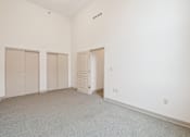 Thumbnail 14 of 18 - A room with white walls and carpeted floor with three closets and one door.